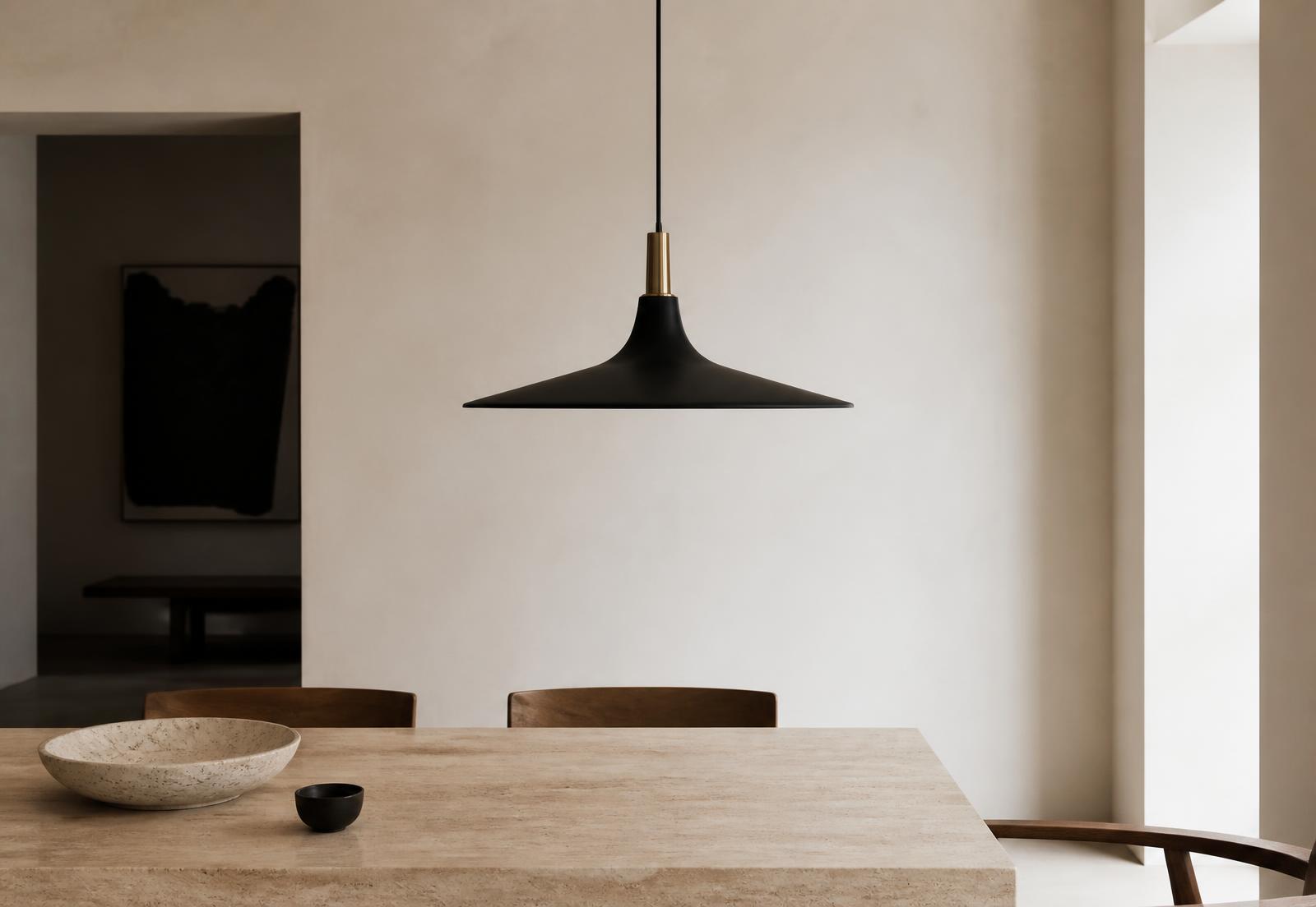 Pendente preto com detalhe em latão sobre mesa de travertino em ambiente de paredes claras